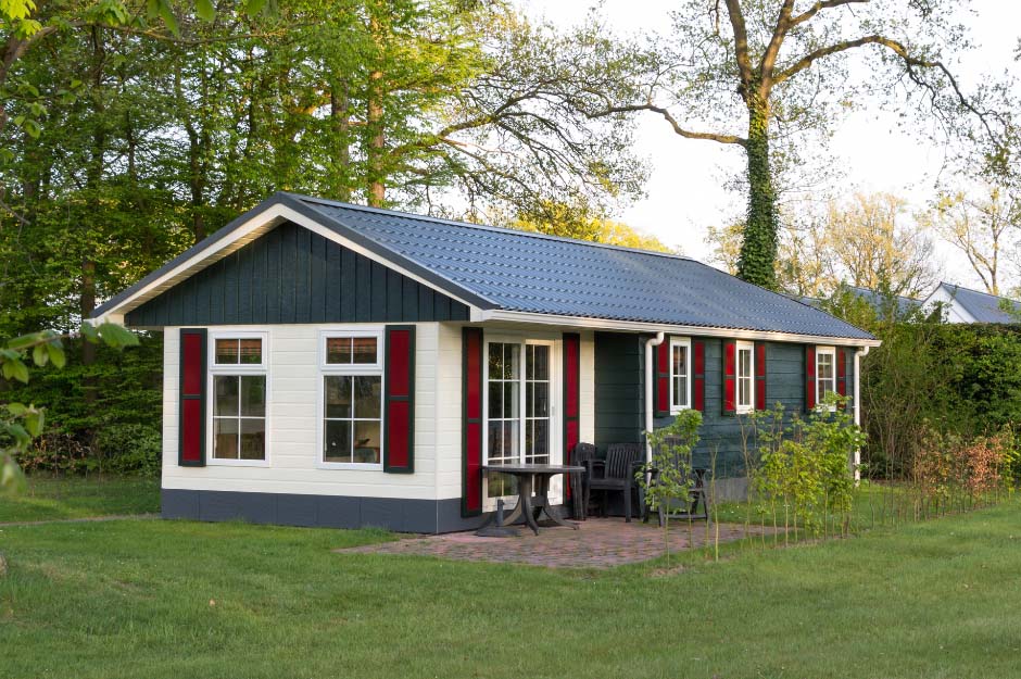 A static caravan style building surrounded by grass and trees. The image is used to symbolise second home mortgages offered by Whitewood Mortgages.